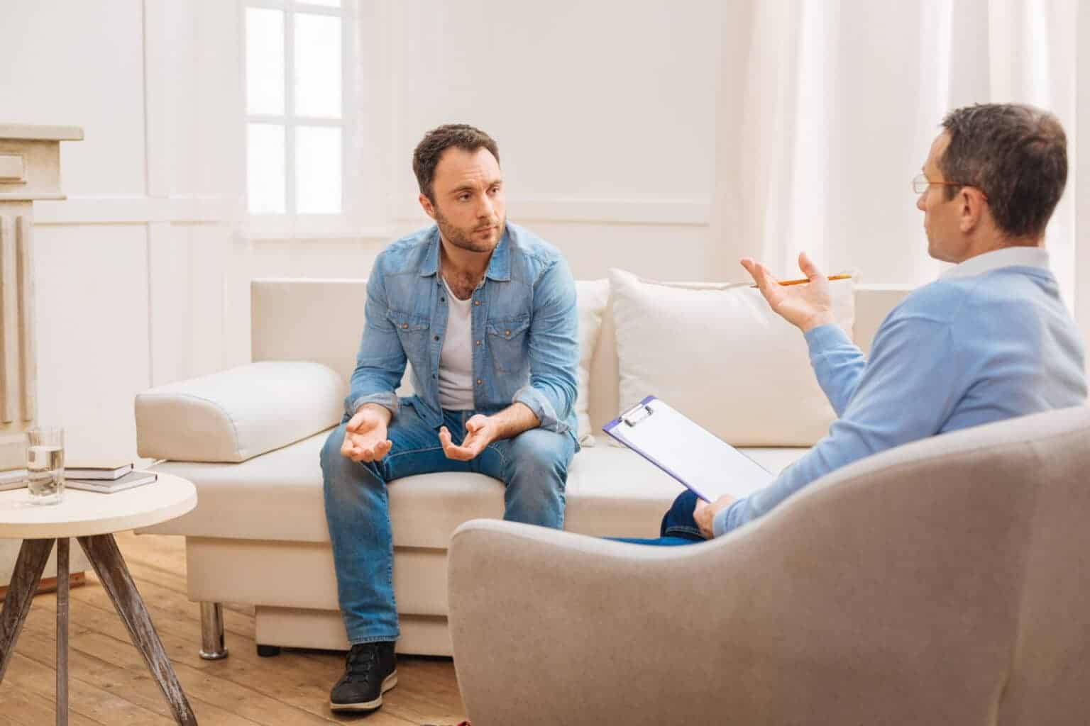 Man in all-denim outfit discussing bigorexia to a therapist